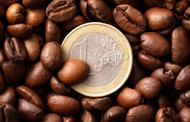 Euro coins on black coffee beans.