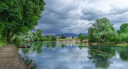 Obraz premium Town of Bihac located on the banks of the Una river which is known for its crystal clear water, rapids and beautiful surrounding nature. There are also two boats and riverside trails.