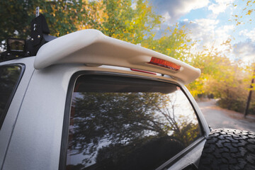 Rear view of a white suv with a spoiler outdoor.