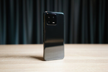 Newest black smartphone on a dark curtains background