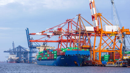 Container ship unloading cargo using Quay Container Crane