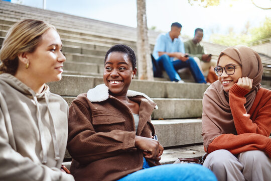 Happy women, diversity or talking on university stairs, school steps or college campus in bonding class break. Smile, black woman or muslim students laughing in relax education group or learning rest