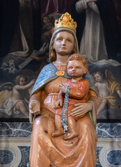 Venzone, Italy - December 29, 2022: Medieval statue of Mary with Jesus in the Cathedral of Saint Andrew in Venzone