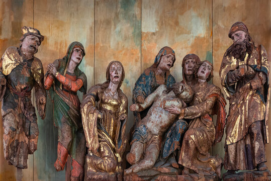 Venzone, Italy - December 29, 2022: Medieval wooden group sculpture of the lamentation of the dead Christ by Giovanpietro da Mure preserved in the cathedral of Saint Andrew apostle in Venzone