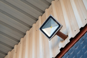 Solar powered led spotlight mounted on the outer wall of the warehouse