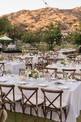 outdoor event, white chairs and tables placed outside