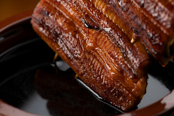 鰻の蒲焼きを秘伝のタレに漬ける