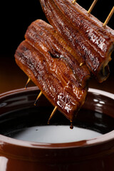 鰻の蒲焼きを秘伝のタレに漬ける