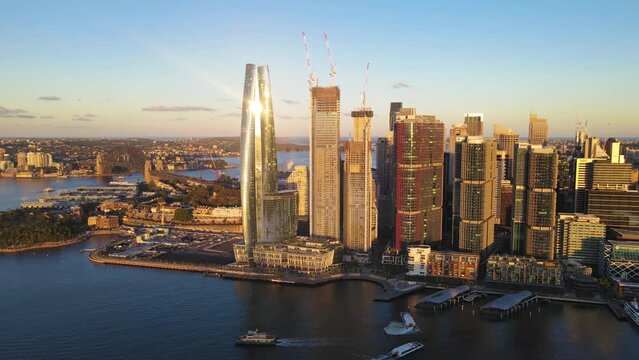 Aerial drone pullback reverse view of Barangaroo waterfront precinct in Sydney City, NSW looking in the east direction on a sunny late afternoon in January 2023    