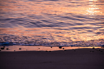 Naklejka premium 昇る朝日に照らされてキラキラと輝く砂浜海岸
