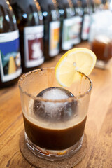 Ice ball in a clear glass of ice americano coffee with warm tone color background of cafe