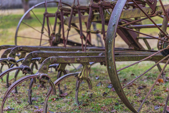 Vintage plowing machine in the field. Old rusted farm machinery. Old rusty plow and planter