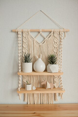A macrame shelf hangs in the interior of the room