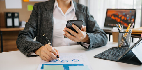 Fototapeta premium woman using tablet while sitting on cellphone at home. Beautiful girl relaxing while chatting on mobile phone at office