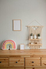 Mockup wooden frame in the interior of the room, macrame shelf and wooden chest of drawers