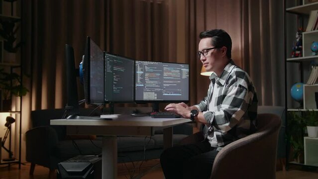 Asian Male Programmer Smiling To Camera While Creating Software Engineer Developing App, Program, Video Game On Desktop Computer At Home. Terminal With Coding Language 
