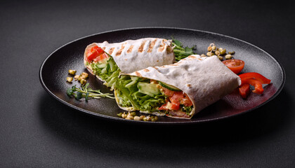 Delicious fresh shawarma with tomatoes, peppers, cucumber on a dark concrete background