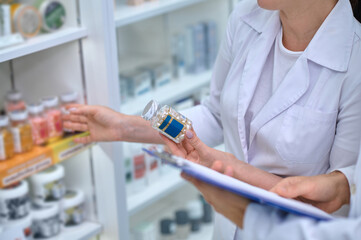 Female pharmacist making inventary in a drugstore
