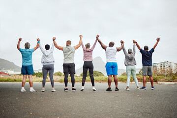 Holding hands, fitness group of people winning, yes or celebration exercise, workout and training goals in city rear. Wellness, community and senior friends teamwork, accountability and success sign