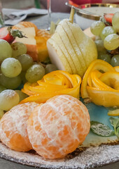 beautiful plate with assorted fruit, citrus fruits with pears and grapes