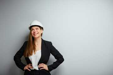 Smiling woman engeneer builder in black business suit looking up, isolated portrait.
