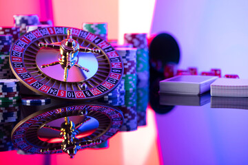 Fototapeta premium Casino theme. Gambling games. Roulette wheel, card and poker chips on red background.