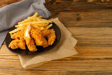 Breaded Fried Chicken Wings, Fingers and Drumsticks on Wooden Rustic Background Side View