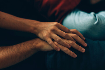 detail of two male hands with crossed fingers one inside the other - love and affection between...