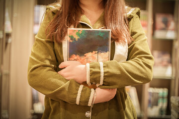 college girl holding book in library