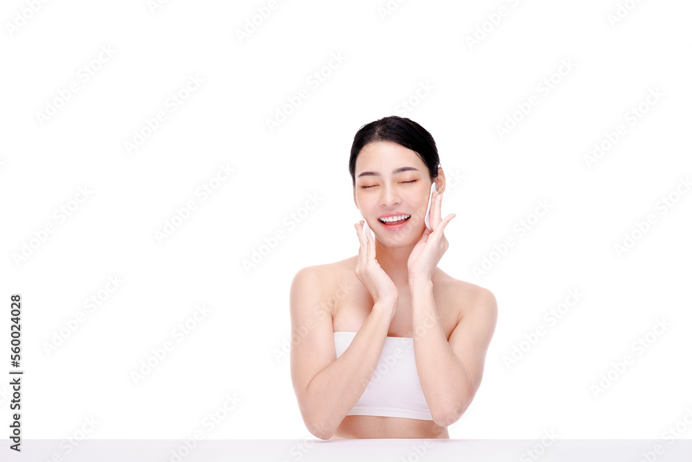 Wall mural Attractive beauty young asian woman clean skin with cotton pad removing make up on white background.