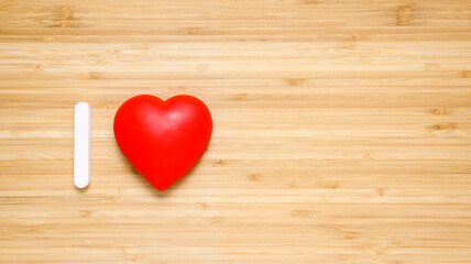 Red heart on a wooden background. Abstract phrase I love. Congratulations on the anniversary or on February 14