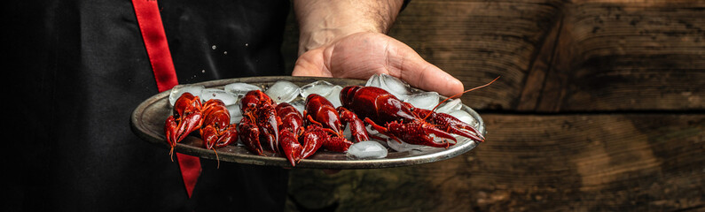 male hands holding boiled crayfish. Concept beer appetizer, delicacy, crayfish meat. Long banner...