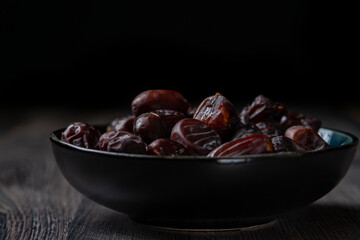 dates and nuts in a bowl on a dark background