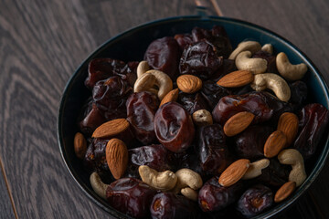 dates and nuts in a bowl on a dark background