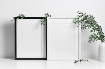 Two poster frames mockup in white scandinavian interior with natural eucalyptus twigs