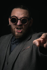 charismatic man in a classic suit and steampunk goggles on a black background stylish Portrait