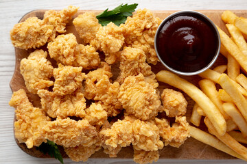 Homemade Popcorn Chicken with BBQ Sauce on a Rustic Wooden Board, top view. Flat lay, overhead, from above.