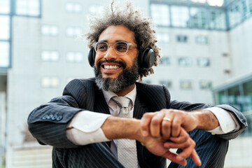 Young entrepreneur business man listening to music and dancing outside the office. Concept about...