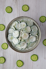Homemade Cucumber Salad with Sour Cream and Onions in a Bowl, top view. Flat lay, overhead, from above.