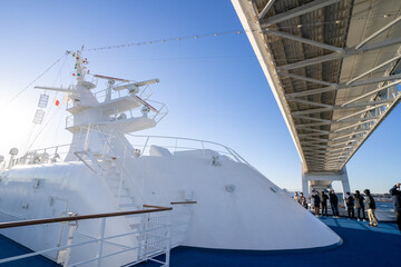 クルーズ客船から橋を見上げる人たち
