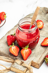Jar of strawberry jam and fresh berries on white background. Homemade strawberry marmelade and fruit