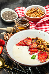 Bowl of homemade granola with fresh strawberry, chia seeds and honey on a light background. Delicious breakfast or snack. banner, menu, recipe place for text, top view