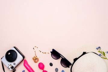 summer travel accessories. women's set of adult toys, camera, hat, glasses on a light background. space for your text