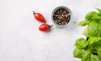 A light background with tomato, spices and fresh basil. The concept of healthy food.