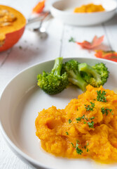 Fitness food side dishes for dinner or lunch with pumpkin puree and broccoli on a plate