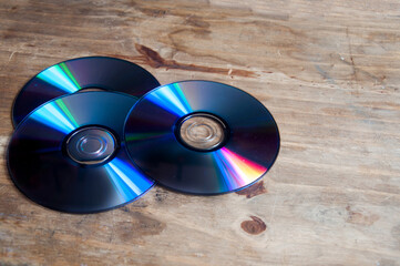 cd and dvd on top of a wooden  background