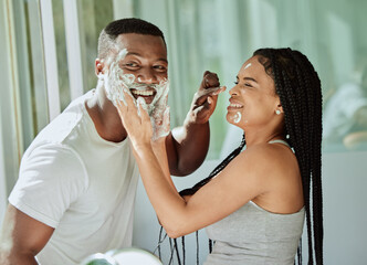 Shaving, playful and fun with a black couple laughing or joking together in the bathroom of their home. Love, shave and laughter with a man and woman being funny while bonding in the morning