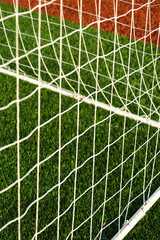 Close up shot of goal post with goal netting and goal line.