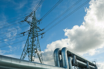 pipeline and power line support on the background of blue sky and clouds