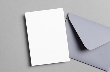 Blank invitation or greeting card mockup with envelope on grey background